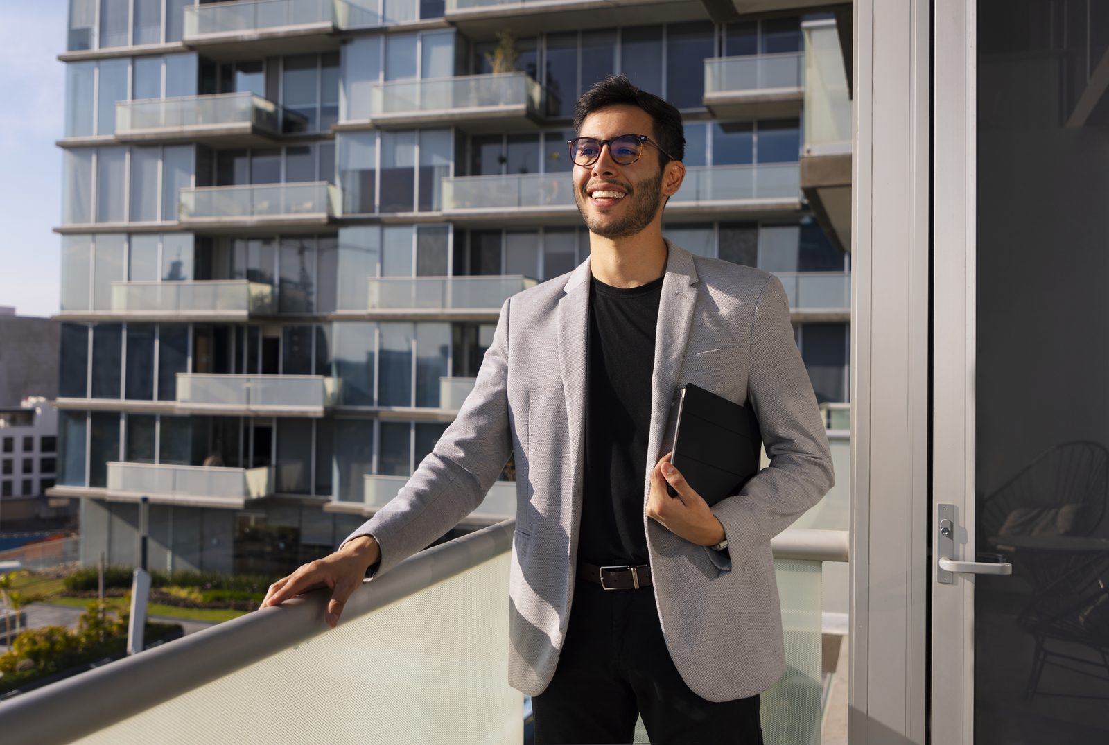 Rafael Monteiro em uma varanda, ao fundo prédios residenciais de São Paulo